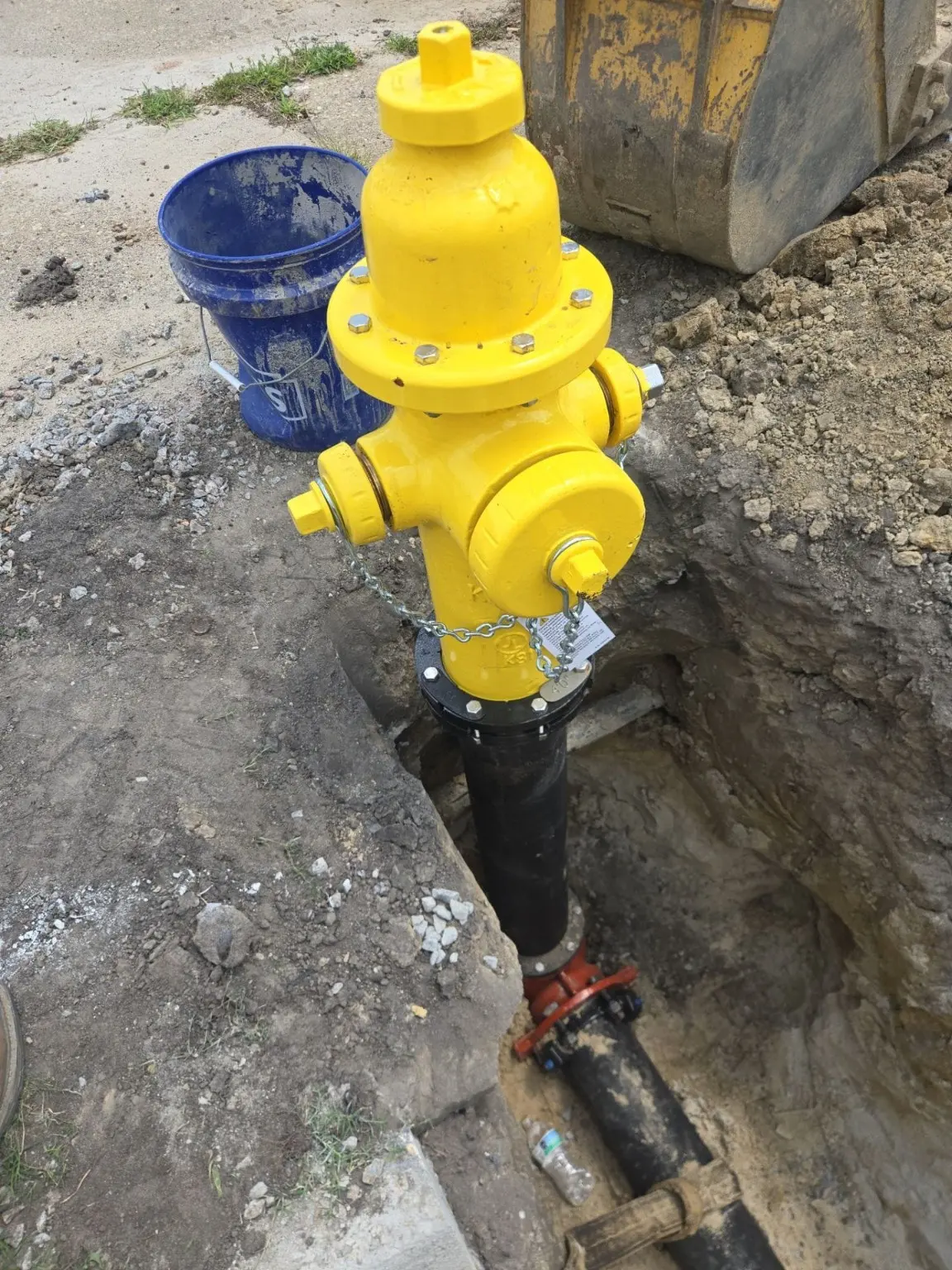 A yellow fire hydrant and underground connection visible during installation.