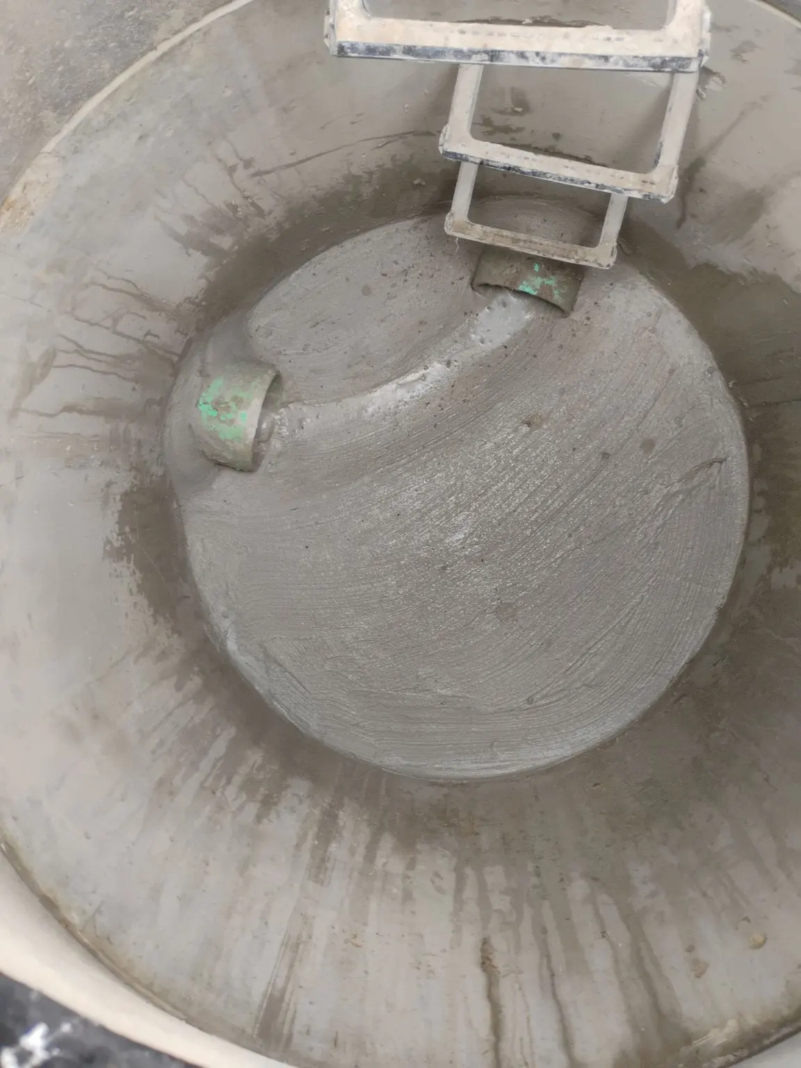 Interior of a concrete manhole with pipe openings and access steps.