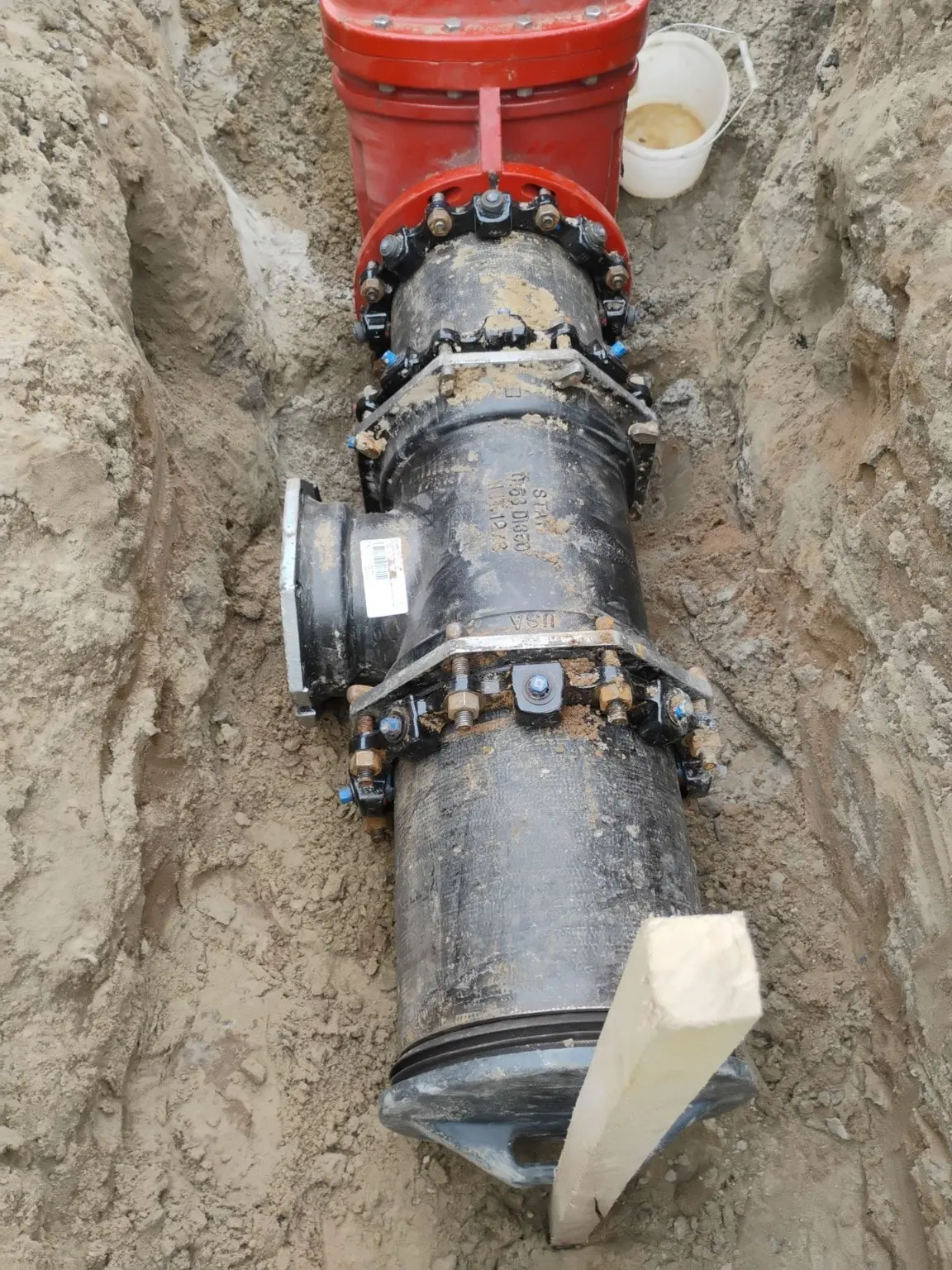 A pipe, fitting, and valve assembly exposed during underground installation.